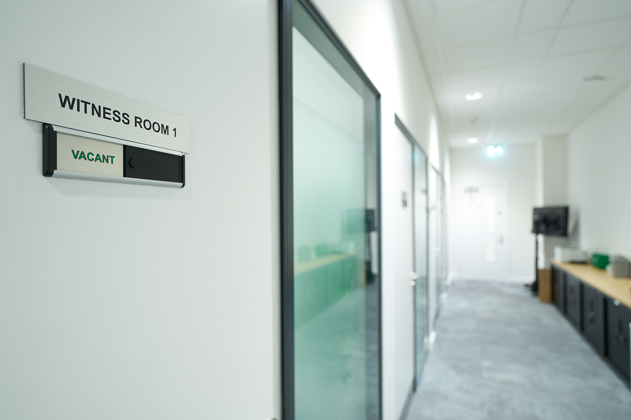 Corridor and image of door with the words witness room