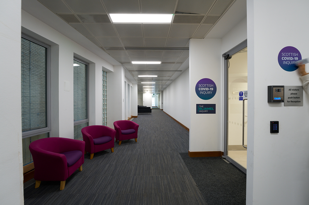 Chairs and signs on wall outside hearing suite entrance