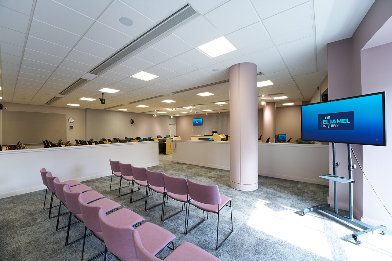 Chairs and a TV screen in the hearing room's public gallery